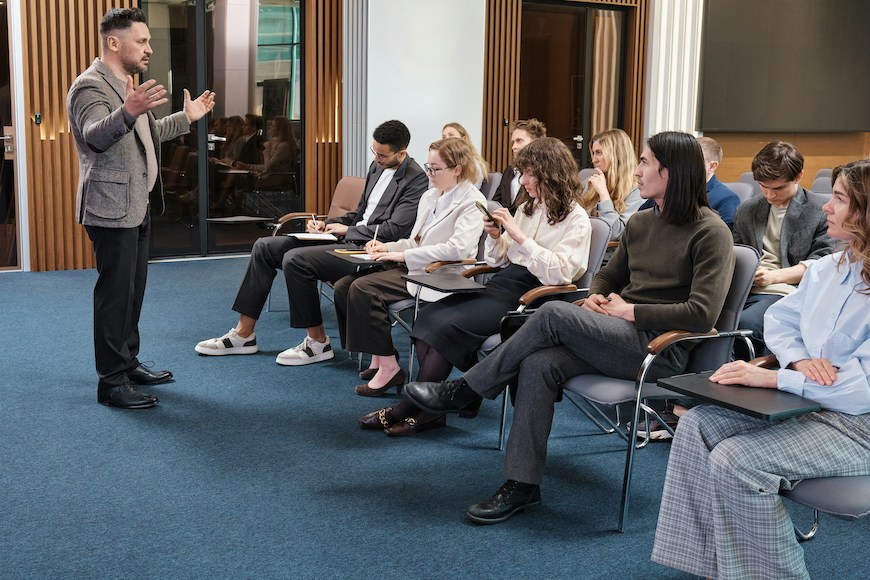 A guest presenter speaks with students in a journalism class.